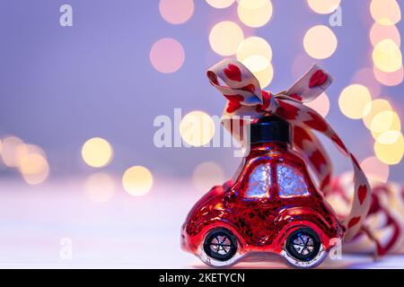 Nahaufnahme, autoförmiges Weihnachtsspielzeug auf unscharfem Hintergrund mit Bokeh. Stockfoto