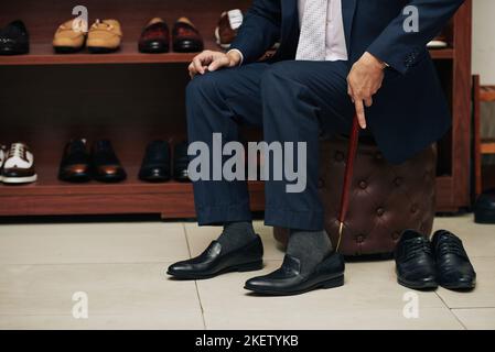 Beschnittenes Bild eines Mannes, der im Laden Schuhe anprobiert Stockfoto