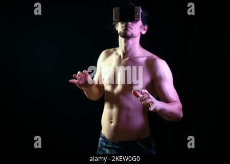 Fit junge Mann allein Ausbildung trotz Coronavirus Pandemie mit Virtual-Reality-Brille Stockfoto