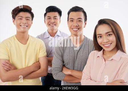 Glücklich lächelnde junge Menschen, die mit beschnittenen Armen stehen Stockfoto