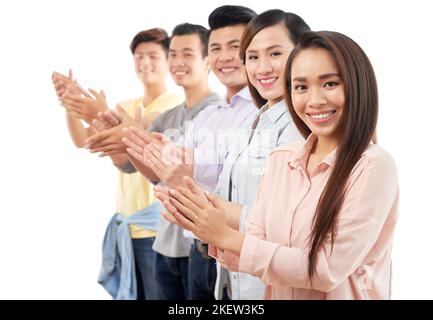 Gruppe von glücklichen jungen asiatischen Geschäftsleuten, die applaudieren Stockfoto