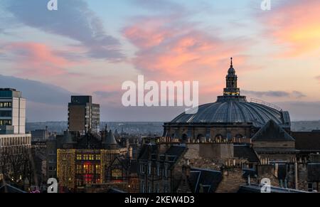 Edinburgh, Schottland, Großbritannien, 14.. November 2022. UK Wetter: Sonnenuntergang über dem Stadtzentrum. Über dem Kuppeldach der McEwan Hall mit Teviot Row House, das in Weihnachtslichtern beleuchtet ist, taucht ein wunderschöner rosa-blauer Sonnenuntergang auf. Kredit: Sally Anderson/Alamy Live Nachrichten Stockfoto