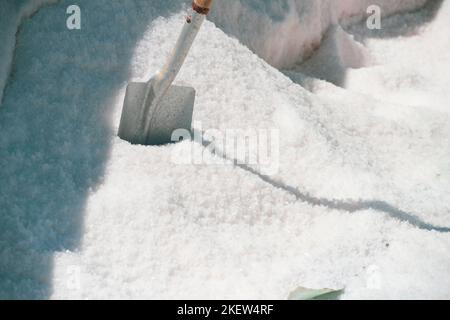 Schaufel in einem Salzhaufen, der aus den Salzebenen entnommen wurde. Stockfoto