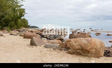 Meerblick mit blauem Himmel, verschiedenen Felsen und grünen Bäumen Stockfoto