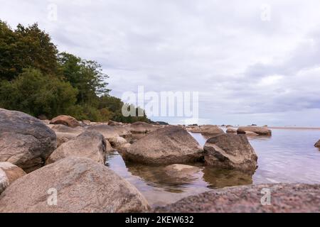 Meerblick mit blauem Himmel, verschiedenen Felsen und grünen Bäumen Stockfoto