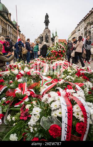 Polen Unabhängigkeitstag in Krakau. Menschen, die Blumen mit polnischen Flaggen neben dem Denkmal von Grunwald am Plac Matejki hinterlassen. Krakau, Polen - 11. November 2022. Stockfoto