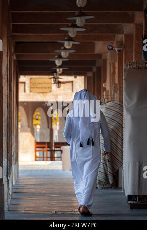 Arabische Männer, die im Souq waqif Doha spazieren, Rückansicht Stockfoto