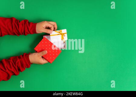 Weibliche Hände nehmen eine Bonus- oder Geschenk-Bankkarte-Vorlage aus einer Geschenkbox für Online-Dienste und Shopping Top-Ansicht, flach liegend Stockfoto