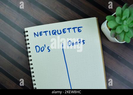 Konzept der Netiquette mit Do's und Don'TS schreiben auf ein Buch isoliert auf Holztisch. Stockfoto