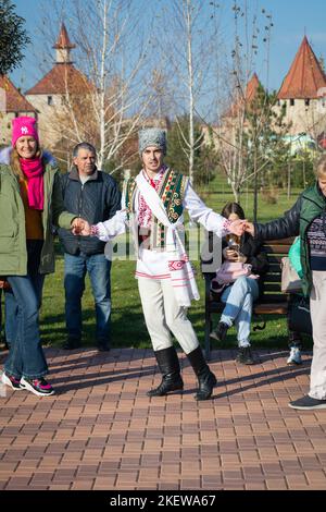 Bendery, Moldawien - 12. November 2022: Menschen tanzen moldawischen Tanz. Männer und Frauen in nationalen Kostümen tanzen am Vorabend den wunderschönen moldawischen chora-Tanz Stockfoto