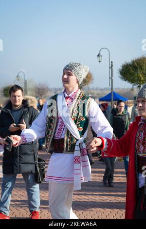 Bendery, Moldawien - 12. November 2022: Menschen tanzen moldawischen Tanz. Männer und Frauen in nationalen Kostümen tanzen am Vorabend den wunderschönen moldawischen chora-Tanz Stockfoto