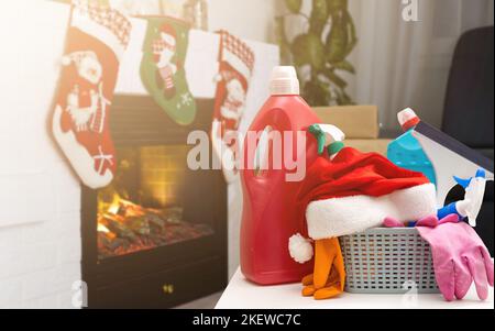 Reinigung vor Weihnachten. Mehrfarbige Reinigungsmittel. Schwämme, Lumpen und Spray mit festlichen Dekorationen vor dem Hintergrund Stockfoto