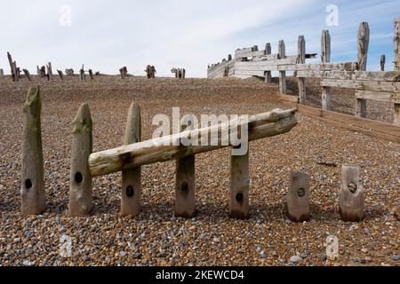 Hölzerne Meeresabwehr (Wellenbrecher oder Groynes) am Strand im Rye Harbour Nature Reserve, Sussex, England. Stockfoto