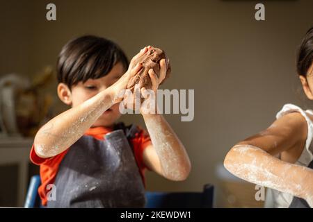 Nahaufnahme der Kinderhände, die den Teig halten Stockfoto