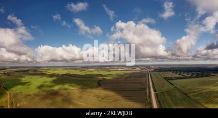 Grünes landwirtschaftliches Feld mit Wolken Schatten und Lichtflecken unter bewölktem Himmel Luftpanorama. Horizont über landschaftlich reizvoller Landschaft Stockfoto