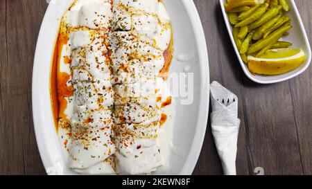 Traditionelle türkische Fleischgerichte Tantuni Wrap serviert mit Joghurt und Gewürzen Stockfoto
