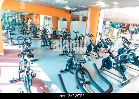 Moderne Innenausstattung des Fitnessraums mit Geräten. Trainingsreihe Heimtrainer Detail, Hintergrundbeleuchtung. Gesundes Lifestyle-Konzept Stockfoto