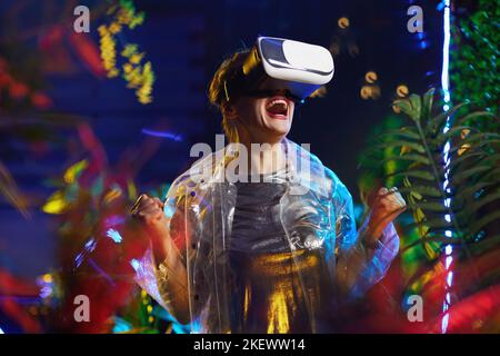 Fröhliche stilvolle Frau in vr Brille jubeln in der virtuellen Realität. Stockfoto