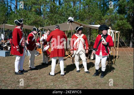 Kershaw, South Carolina, USA. 13.. November 2022. Fans des Revolutionären Krieges und leidenschaftliche Schauspieler stellen die Schlacht von Camden, SC, nach, sodass Besucher während des Krieges um die Unabhängigkeit von der britischen Herrschaft lebendige Geschichte erleben können. Die Schlacht von Camden, die 1780 ausgetragen wurde, war eine von mehreren verheerenden Niederlagen, die die Amerikaner in den frühen Phasen der britischen Militäroffensive im Süden erlitten haben. Im Bild: Britische ''˜Redcoats' machen sich bereit für den Kampf am Nachmittag (Bild: © Robin Rayne/ZUMA Press Wire) Stockfoto