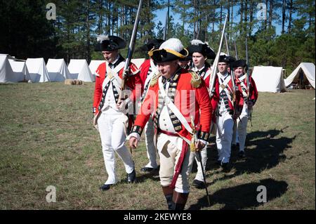 Kershaw, South Carolina, USA. 13.. November 2022. Fans des Revolutionären Krieges und leidenschaftliche Schauspieler stellen die Schlacht von Camden, SC, nach, sodass Besucher während des Krieges um die Unabhängigkeit von der britischen Herrschaft lebendige Geschichte erleben können. Die Schlacht von Camden, die 1780 ausgetragen wurde, war eine von mehreren verheerenden Niederlagen, die die Amerikaner in den frühen Phasen der britischen Militäroffensive im Süden erlitten haben. Im Bild: Britische ''˜Redcoats' machen sich bereit für den Kampf am Nachmittag (Bild: © Robin Rayne/ZUMA Press Wire) Stockfoto