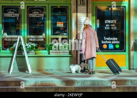 Danzig, Polen - 11. März 2022: Tourist mit einem kleinen Hund am Eingang zu einer Bar in Danzig. Reisen Stockfoto