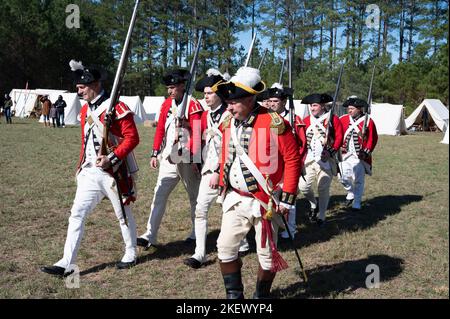 Kershaw, South Carolina, USA. 13.. November 2022. Fans des Revolutionären Krieges und leidenschaftliche Schauspieler stellen die Schlacht von Camden, SC, nach, sodass Besucher während des Krieges um die Unabhängigkeit von der britischen Herrschaft lebendige Geschichte erleben können. Die Schlacht von Camden, die 1780 ausgetragen wurde, war eine von mehreren verheerenden Niederlagen, die die Amerikaner in den frühen Phasen der britischen Militäroffensive im Süden erlitten haben. Im Bild: Britische ''˜Redcoats' machen sich bereit für den Kampf am Nachmittag (Bild: © Robin Rayne/ZUMA Press Wire) Stockfoto