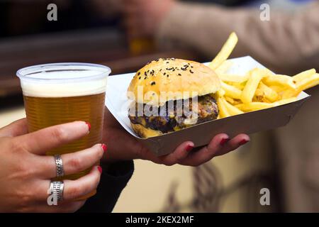 Ein Glas Craft-Blondes-Bier und Burger mit Pommes Frites Stockfoto