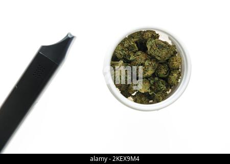 Cannabis flos, medizinisches Marihuana in weißem Behälter neben Verdampfer, sichere Art und Weise, Medizin zu nehmen Stockfoto