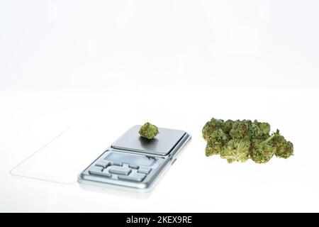 Cannabisflos, medizinisches Marihuana stapeln sich neben einer Präzisionswaage, sichere Art, Medizin einzunehmen Stockfoto