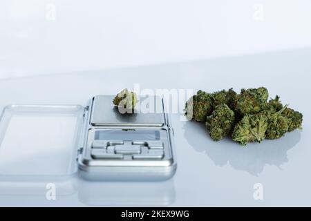 Cannabisflos, medizinisches Marihuana stapeln sich neben einer Präzisionswaage, sichere Art, Medizin einzunehmen Stockfoto