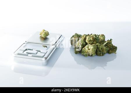 Cannabisflos, medizinisches Marihuana stapeln sich neben einer Präzisionswaage, sichere Art, Medizin einzunehmen Stockfoto