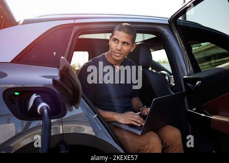 Nachdenklicher Mann mit Laptop im Auto Stockfoto