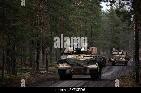 Ein m2 Bradley Kampffahrzeug, das 6. Squadron, 9. Kavallerieregiment, 3. Panzerbrigade-Kampfteam, 1. Kavallerie-Division (3-1 ABCT), operativ der 1. Infanterie-Division (1 ID) zugewiesen wurde, Scouts vor einem M1 Abrams Panzer während Hammer 22, Eine jährliche kombinierte Streitkräfteübung, die von und neben dem finnischen Armeehauptquartier, der Panzerbrigade, der Pori-Brigade, der Karelia-Brigade, dem UTI-Jaeger-Regiment und dem Logistikministerium der Streitkräfte in Niinisalo, Finnland, am 4. November 2022 durchgeführt wird. Die 3-1 ABCT arbeitet unter anderem unter der ID 1 stolz mit Verbündeten und regionalen Verbündeter zusammen Stockfoto