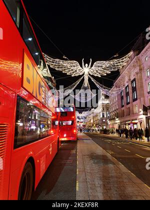 Spirit of Christmas, auch bekannt als Angels, schwebte über der Regent Street, während die Busse unten vorbeifuhren und Touristen auf dem Bürgersteig spazieren gingen. Nach London. Stockfoto