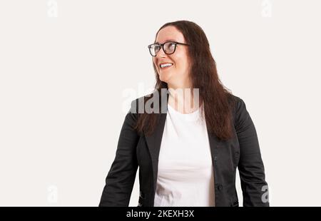Schöne kaukasische Geschäftsfrau, die über einem isolierten weißen Hintergrund steht und mit einem Lächeln auf dem Gesicht, einem natürlichen Ausdruck, zur Seite schaut. Lachend confi Stockfoto