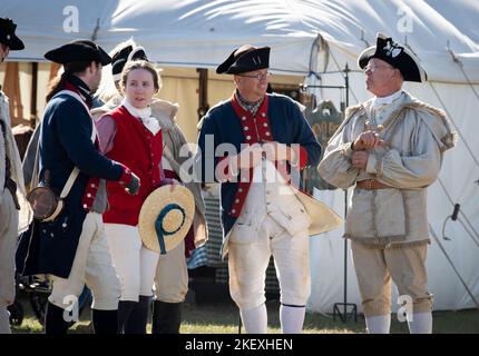 Kershaw, South Carolina, USA. 13.. November 2022. Fans des Revolutionären Krieges und leidenschaftliche Schauspieler stellen die Schlacht von Camden, SC, nach, sodass Besucher während des Krieges um die Unabhängigkeit von der britischen Herrschaft lebendige Geschichte erleben können. Die Schlacht von Camden, die 1780 ausgetragen wurde, war eine von mehreren verheerenden Niederlagen, die die Amerikaner in den frühen Phasen der britischen Militäroffensive im Süden erlitten haben. Im Bild: Koloniale Re-enactors genießen die Freundschaften beim Living History Event (Foto: © Robin Rayne/ZUMA Press Wire) Stockfoto