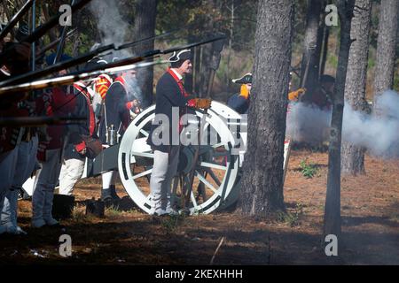 Kershaw, South Carolina, USA. 13.. November 2022. Fans des Revolutionären Krieges und leidenschaftliche Schauspieler stellen die Schlacht von Camden, SC, nach, sodass Besucher während des Krieges um die Unabhängigkeit von der britischen Herrschaft lebendige Geschichte erleben können. Die Schlacht von Camden, die 1780 ausgetragen wurde, war eine von mehreren verheerenden Niederlagen, die die Amerikaner in den frühen Phasen der britischen Militäroffensive im Süden erlitten haben. Im Bild: Britische Artillerie- und Infanteriedarsteller porträtieren die Schlacht (Bild: © Robin Rayne/ZUMA Press Wire) Stockfoto