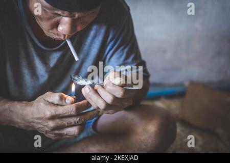 Süchtige Junkie Mann, der Drogen vorbereitet. Mann, der Drogen nimmt, das Konzept von Kriminalität und Drogenabhängigkeit. Heroinabhängiger in der Dunkelheit, No to Drugs Konzept. Stockfoto