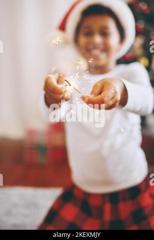 Bezaubernde dunkle Hautfarbe für Jungen in festlichem Kostüm, unterhaltsam mit bengalischen Lichtern Stockfoto