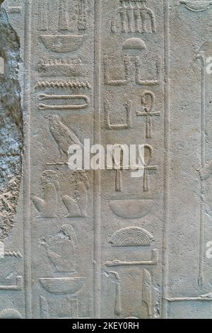 Alter Text in Form von ägyptischen Hieroglyphen auf einer Wand aus Kalkstein Stockfoto