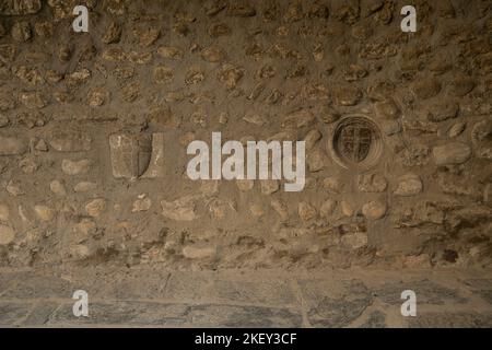 Alte Steinschilde an der Wand des Kreuzgangs. Kathedrale von La Seu d'Urgell. Katalanische romanische Architektur. 12. Cent. La Seu d’Urgell. Alt Urgell. Lle Stockfoto