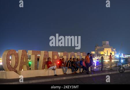 Doha, Katar. 14.. November 2022. Die Menschen ruhen am 14. November 2022 in Doha, Katar, in der Nähe einer Installation der FIFA-Weltmeisterschaft 2022. Kredit: Nikku/Xinhua/Alamy Live Nachrichten Stockfoto