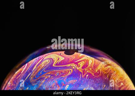 Virtual Reality Raum mit abstrakten multicolor psychedelischen Planeten. Nahaufnahme Seifenblase wie ein außerirdischer Planet auf schwarzem Hintergrund Stockfoto