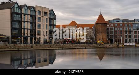 Danzig, Polen Mai 2022, moderne Gebäude über dem Motlawa-Fluss in der Altstadt. Tourismus auf dem Motlawa River. Neue Apartments-Architektur auf Granary Island Glasfenster mit Reflexionen. Touristisches Reiseziel Stockfoto