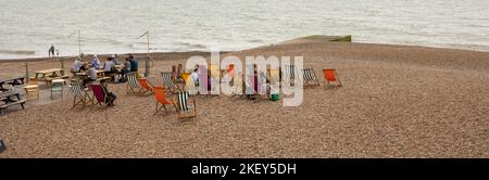 Hastings, united Kingdom, 24, August 2022 Sonnenanbeter und Tagesausflügler entspannen sich am Kiesstrand auf farbenfrohen Liegestühlen Stockfoto