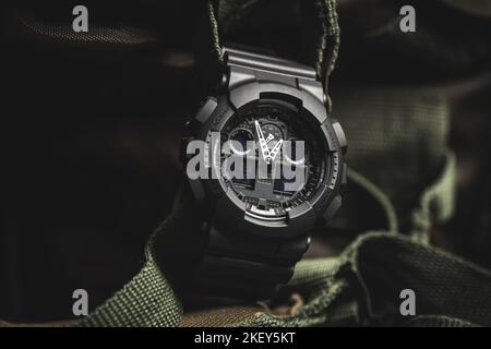 Nahaufnahme einer schwarzen analog-digitalen Hybrid-Sportarmbanduhr. Lässiges Accessoire für Herren. Stockfoto