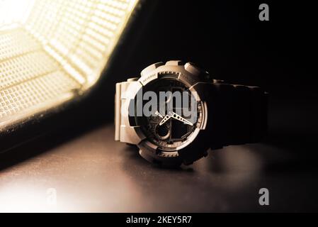 Nahaufnahme einer schwarzen analog-digitalen Hybrid-Sportarmbanduhr. Lässiges Accessoire für Herren. Stockfoto