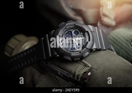 Nahaufnahme einer schwarzen analog-digitalen Hybrid-Sportarmbanduhr. Lässiges Accessoire für Herren. Stockfoto