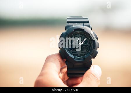 Nahaufnahme einer schwarzen analog-digitalen Hybrid-Sportarmbanduhr. Lässiges Accessoire für Herren. Stockfoto