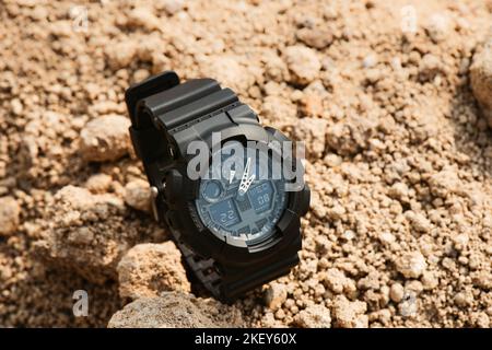 Nahaufnahme einer schwarzen analog-digitalen Hybrid-Sportarmbanduhr. Lässiges Accessoire für Herren. Stockfoto